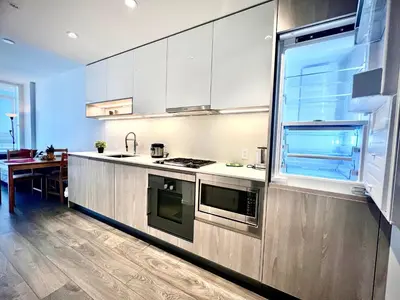 a kitchen with stainless steel appliances and a table at Stylish 1B1B locates in the heart of Richmond in Richmond