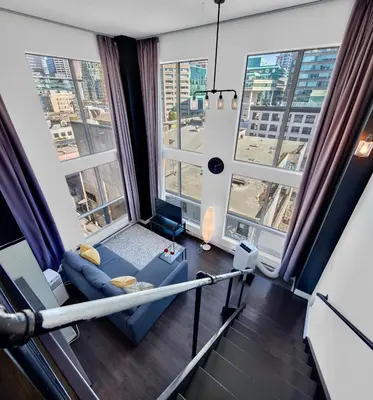 a room with large windows and a couch in a room at Trendy Downtown Loft Apartment - King Bed! in Vancouver