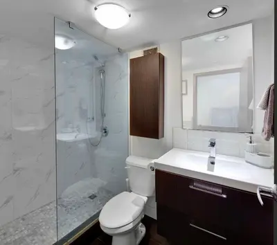 a bathroom with a shower and a toilet and a sink at Trendy Downtown Loft Apartment - King Bed! in Vancouver