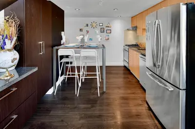 a kitchen with a table and a refrigerator at Trendy Downtown Loft Apartment - King Bed! in Vancouver
