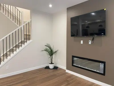 a living room with a tv and a plant at Full AC Brand New House with 3 Bedroom in Airdrie