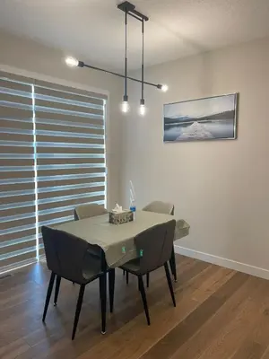 a dining room with a table and chairs at Full AC Brand New House with 3 Bedroom in Airdrie