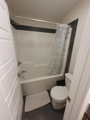 a small bathroom with a toilet and a shower at Full AC Brand New House with 3 Bedroom in Airdrie