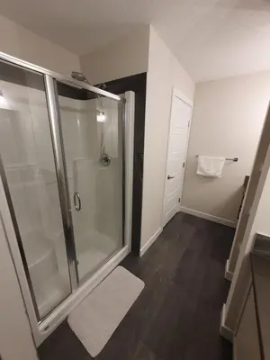 a bathroom with a shower with a glass shower stall at Full AC Brand New House with 3 Bedroom in Airdrie