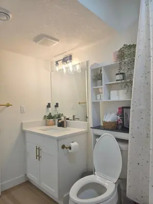 a bathroom with a toilet and a sink and a mirror at Amaville- The Cozy Cave - Minutes to WEM & YEG in Edmonton