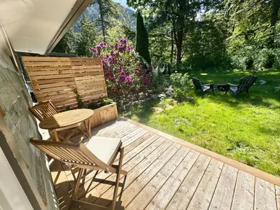 a deck with two chairs and a bench on it at Posada Nordica - a chic, tranquil mountainview suite in Hope