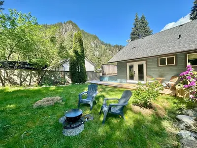 two chairs and a grill in the yard of a house at Posada Nordica - a chic, tranquil mountainview suite in Hope