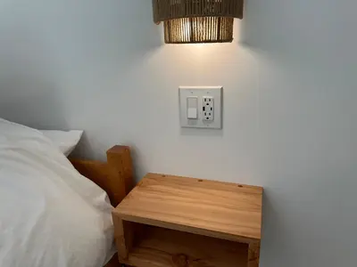 a bedroom with a bed and a lightswitch on the wall at Posada Nordica - a chic, tranquil mountainview suite in Hope