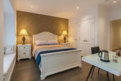 a bedroom with a white bed with two night stands and a desk at Lisa's house in Richmond