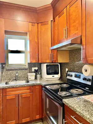 a kitchen with wooden cabinets and a stove top oven at Central & Comfy 1B1B in Vancouver