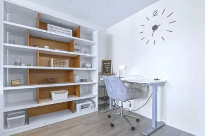 an office with a desk and a clock on the wall at Cozy & Spacious 2BR at Stampede w Parking and AC in Calgary
