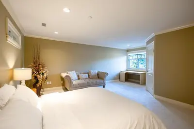 a bedroom with a bed and a couch and a window at Luxury 5BR Villa, Gym, Theater & Ocean Views in West Vancouver