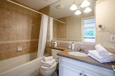 a bathroom with a sink and a tub and a toilet at Luxury 5BR Villa, Gym, Theater & Ocean Views in West Vancouver