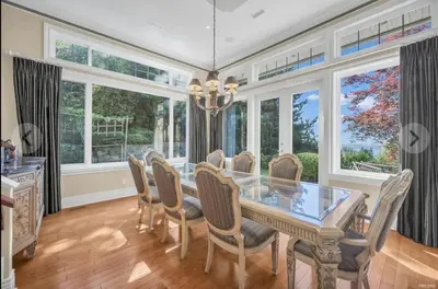 a dining room with a glass table and chairs at Luxury 5BR Villa, Gym, Theater & Ocean Views in West Vancouver