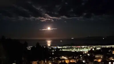 a plane is flying over the water at night at Winter Deal! Stunning Ocean View Modern 1 BDR Private Entry Suite in Colwood