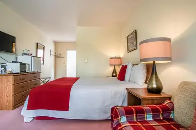 a hotel room with a bed and a chair at Gables Motel in Radium Hot Springs