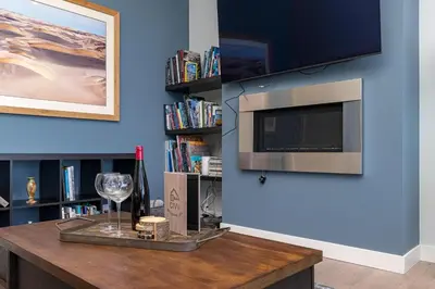 a room with a table with a wine glass and a tv at Come On In, The Water View Is Waiting For You,,, in Oak Bay