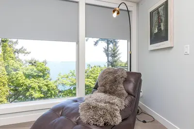 a teddy bear sitting on a leather chair in front of a window at Come On In, The Water View Is Waiting For You,,, in Oak Bay