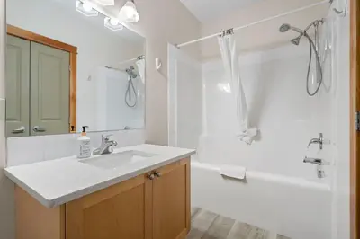 a bathroom with a sink and a tub and a shower at Heated Outdoor Pool & Tubs 9 Guests in Canmore