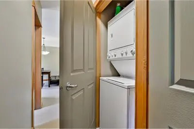 a kitchen with a washer and dryer next to a door at Heated Outdoor Pool & Tubs 9 Guests in Canmore