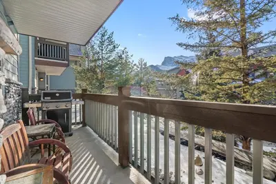 a balcony with a stove and a grill at Heated Outdoor Pool & Tubs 9 Guests in Canmore
