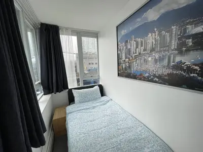 a bedroom with a bed and a painting on the wall at Lucy's House in Vancouver