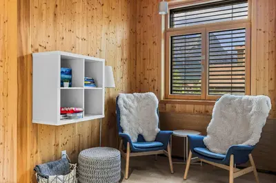 two chairs and a table in a room with wooden walls at Alps #201- LEED Gold Certified in Canmore