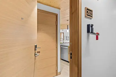 a wooden door with a sign on it next to a kitchen at Pyrenees #202 - LEED Gold Certified in Canmore
