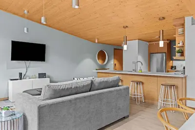 a living room with a couch and a kitchen at Pyrenees #202 - LEED Gold Certified in Canmore
