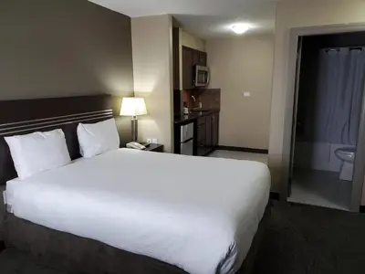 a hotel room with a large bed and a bathroom at Royal Lodge in Edmonton