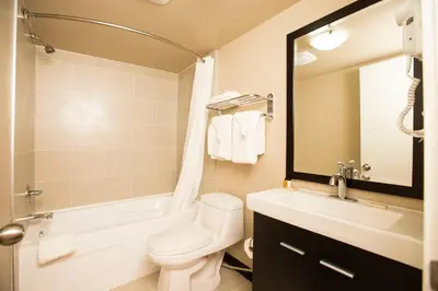 a bathroom with a white toilet and a sink at Royal Lodge in Edmonton