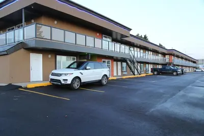 a white car parked in a parking lot in front of a building at Royal Lodge in Edmonton