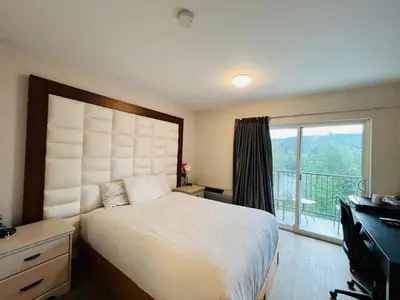 a bedroom with a large bed and a balcony at Hotel Civilia Lakeside by Civilia Golf Retreat in Clearwater