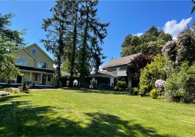 a house with a yard with green grass and trees at Quarrystone House B&B in Fernwood
