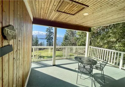 a patio with a table and chairs on a deck at Quarrystone House B&B in Fernwood