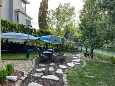 a backyard with a surfboard and a fire pit at Calgary Lake House B&B in Calgary