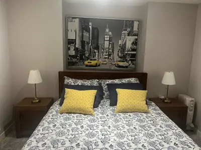a bedroom with a bed with two lamps and a picture on the wall at Calgary Lake House B&B in Calgary