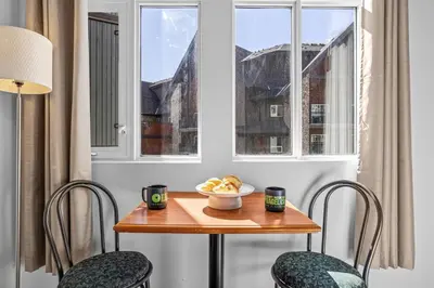 a table with a bowl of food and two chairs at Chic Mountain Hideout in Canmore DT Near Banff! in Canmore