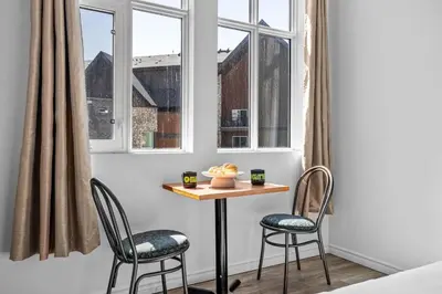 a table and two chairs in a room with windows at Perfect Canmore Getaway for 4 plus Exclusive Savings in Canmore