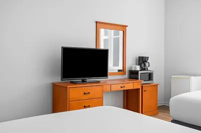 a bedroom with a bed and a television on a dresser at Perfect Canmore Getaway for 4 plus Exclusive Savings in Canmore