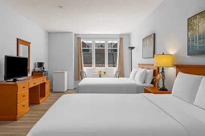 a hotel room with two beds and a flat screen tv at Perfect Canmore Getaway for 4 plus Exclusive Savings in Canmore
