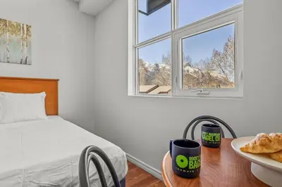 a bedroom with a bed and a table with a plate of bread at Comfy Rockies Retreat for 4 Canmore DT Near Banff in Canmore