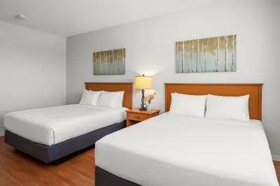 two beds in a hotel room with white sheets at Comfy Rockies Retreat for 4 Canmore DT Near Banff in Canmore