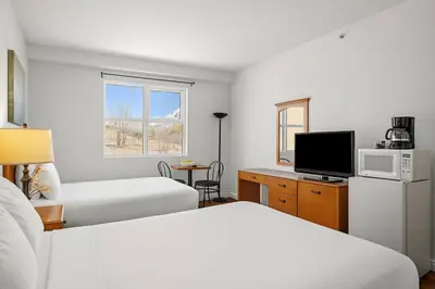a hotel room with two beds and a television at Comfy Rockies Retreat for 4 Canmore DT Near Banff in Canmore