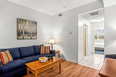 a living room with a blue couch and a table at Cozy Hideaway with MTN Views Near DT Canmore and Banff in Canmore