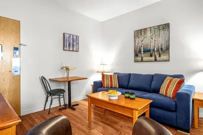 a living room with a blue couch and a table at Cozy Hideaway with MTN Views Near DT Canmore and Banff in Canmore