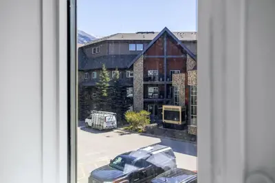a view from a window of a building with a car at Canmore Getaway 2 Beds plus Savings in Canmore