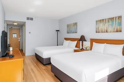 a hotel room with two beds and a flat screen tv at Canmore Getaway 2 Beds plus Savings in Canmore