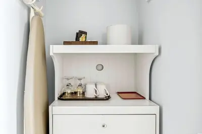 a white cabinet with a shelf and glasses on it at Serene 1BR Retreat with Mountain Views in Canmore