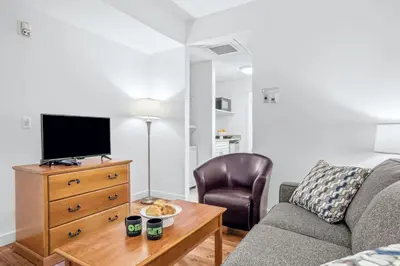 a living room with a couch and a tv and a table at Serene 1BR Retreat with Mountain Views in Canmore